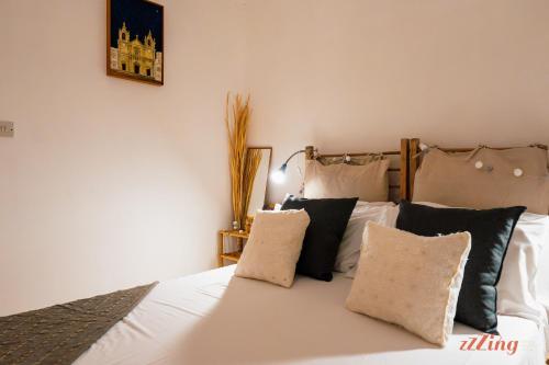 een slaapkamer met een bed met witte lakens en kussens bij A magical getaway by the sea in Marsalforn