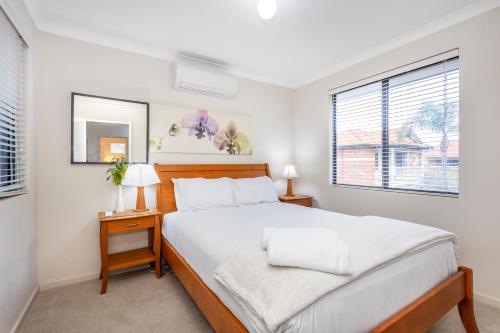 a bedroom with a large bed and a window at Coode Street Townhouse in Perth