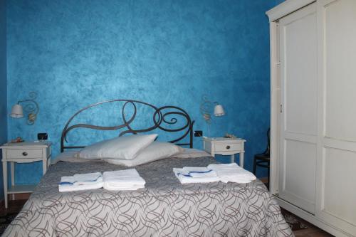 VillamarにあるB&B la Pavoncellaの青いベッドルーム(タオル付きのベッド付)