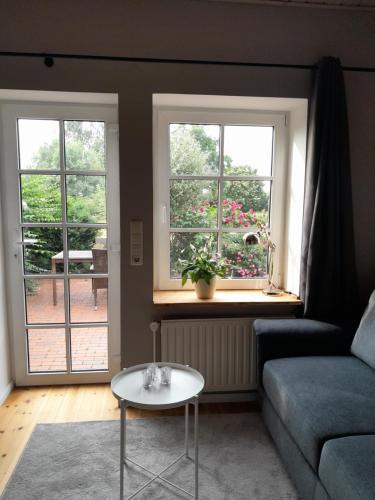 a living room with a couch and two windows at Ferienwohnung Wussegel in Hitzacker