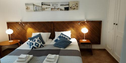 um quarto com uma cama grande e almofadas azuis e brancas em Casa Albacor em Vilamoura