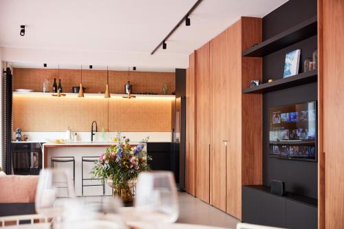 - une cuisine et une salle à manger avec une table fleurie dans l'établissement The Pink Penthouse, à La Panne