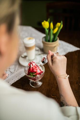 a woman sitting at a table with a bowl of ice cream at Nordowi Dwór in Celbowo