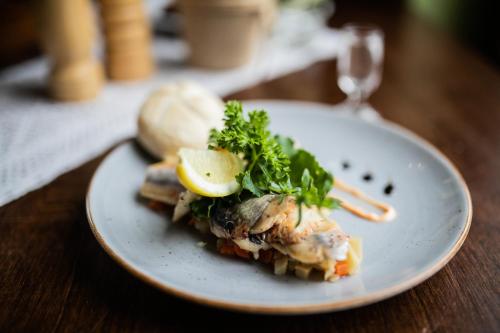 a white plate of food on a wooden table at Nordowi Dwór in Celbowo