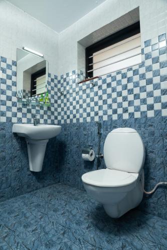 a bathroom with a toilet and a sink at Babira Brookside Heritage Resort in Kumarakom