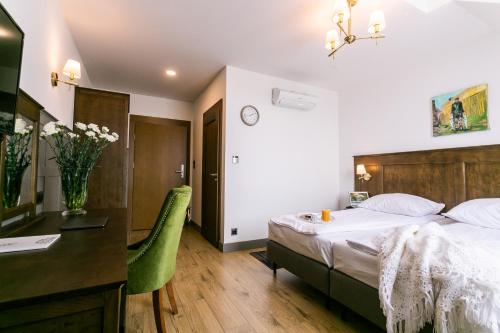 a hotel room with a bed and a desk at Nordowi Dwór in Celbowo