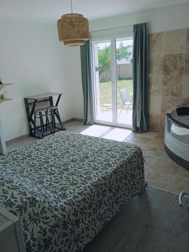 a bedroom with a bed and a sliding glass door at Charme et détente in Allex
