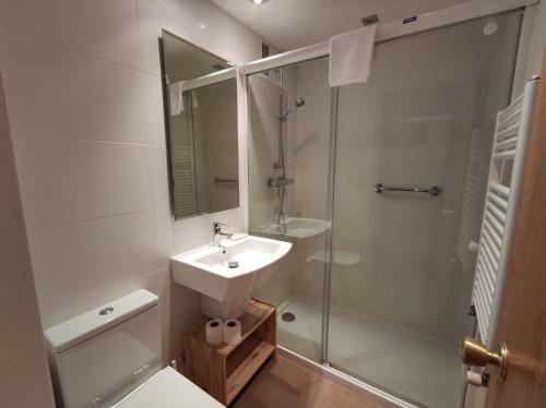 y baño blanco con lavabo y ducha. en Inmocyma El Sarrau-Cerler, en Cerler