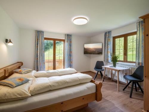- une chambre avec un lit, une table et des chaises dans l'établissement Landhaus Geig, à Hopfgarten im Brixental