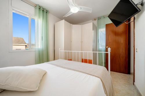 a bedroom with a white bed and a window at Atico Duplex Pepe y Rosi in Cunit