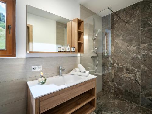 La salle de bains est pourvue d'un lavabo et d'une douche. dans l'établissement Landhaus Geig, à Hopfgarten im Brixental