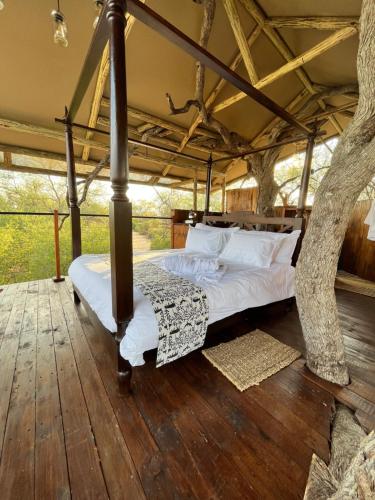 a bedroom with a bed in a tree house at Ondudu Safari Lodge in Omaruru