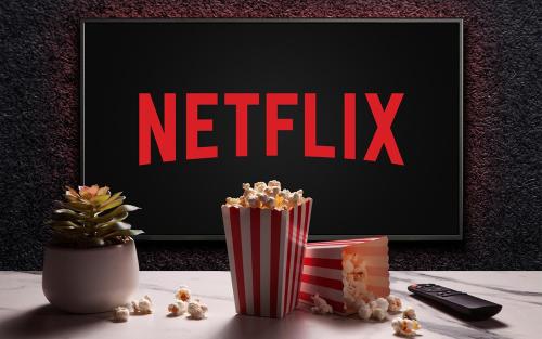 a table with popcorn and a tv with the netflix at Confortable Studio proche Paris et Eurodisney in Villemomble