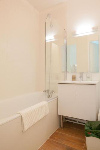 a white bathroom with a sink and a shower at Confortable Studio proche Paris et Eurodisney in Villemomble