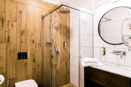 a bathroom with a shower and a toilet and a mirror at Nordowi Dwór in Celbowo