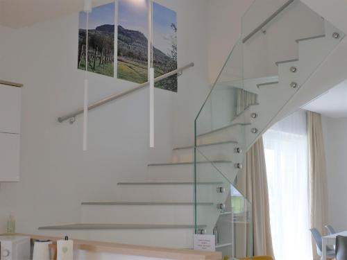 una escalera de cristal en una casa con una foto en la pared en ADELINA Apartman, 