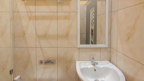 a bathroom with a sink and a mirror at Urbanview Hotel Sakura Kampung Inggris Pare by RedDoorz in Pare