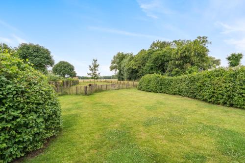 a garden with hedges and a fence at VAKANTIEWONING HUYZE ANNE MARIA in Damme