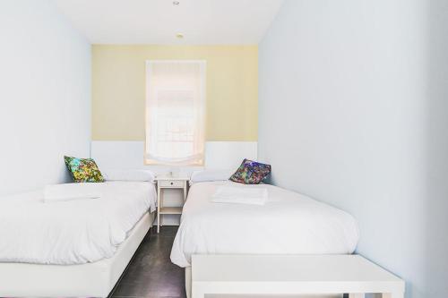 two beds in a small room with a window at Casa Rural Duran in Mocejón