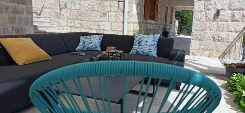 a blue chair sitting in front of a couch at Villa Lucija Cilipi in Čilipi