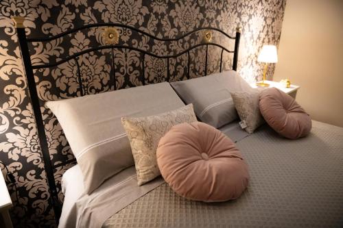 una camera da letto con letto, testiera e cuscini di LA TERRAZZA DEI GEMELLI - casa vacanze a Venosa