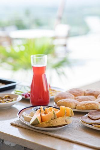 a table with plates of food and a glass of ketchup at Solana's View - Ferienhäuser in ruhiger Lage, mit einer einzigartigen Aussicht, Infinity Pool, Free Parking und Wlan in Ulcinj