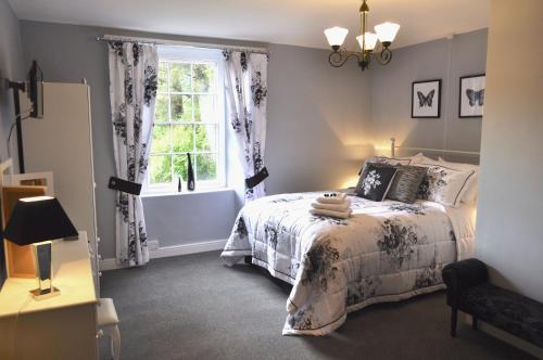 a bedroom with a bed and a window at Dunster Mill House in Dunster