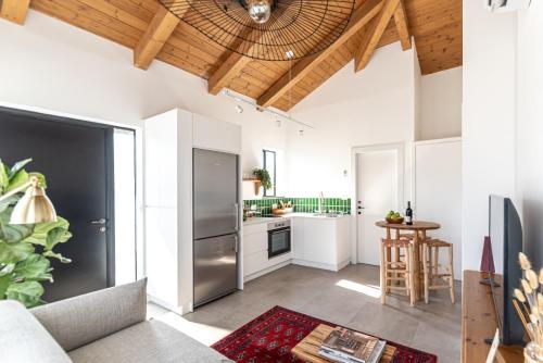 a kitchen with white walls and a wooden ceiling at סטייל בקיבוץ in Kefar Szold