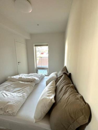 a bedroom with two pillows on a bed with a window at Stor leilighet sentralt i Sandnes in Sandnes