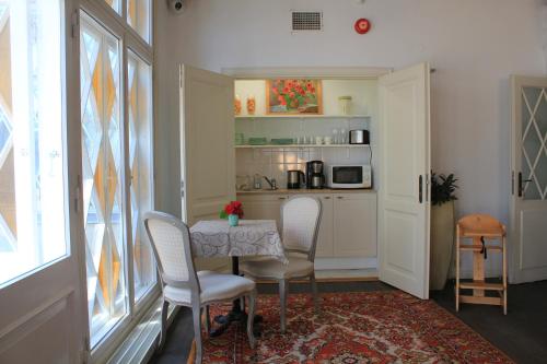 a dining room with a table and chairs and a kitchen at Taanilinna Hotell in Tallinn