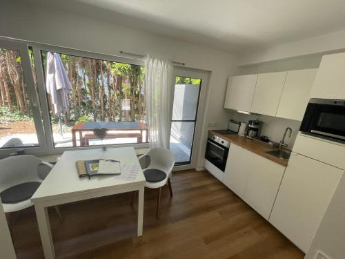 a kitchen with a white table and chairs and a table and a window at ROSMARIN - Kuschelige Fewo - Romantik & Entspannung im Whirlpool auf privater Terrasse, Ruhe & Hund willkommen - by FerienWohnenAmSee - in Überlingen