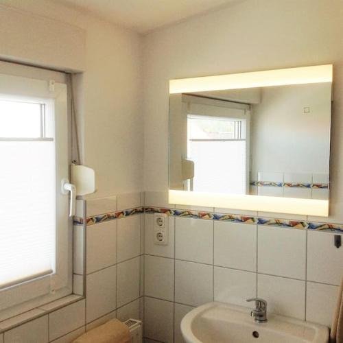 a bathroom with a sink and a mirror at Gemütliche 2 Zimmerwohnung mit tollem Ausblick in Calden