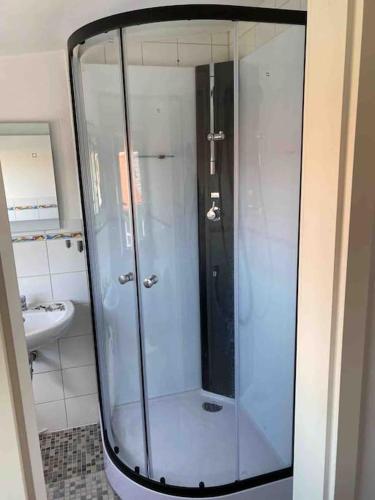 a shower with a glass door in a bathroom at Gemütliche 2 Zimmerwohnung mit tollem Ausblick in Calden