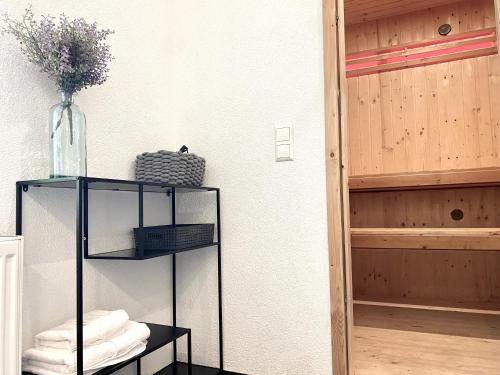 a room with a shelf with towels and a vase at *Schwarzwald-Apartment 2° * in Elzach