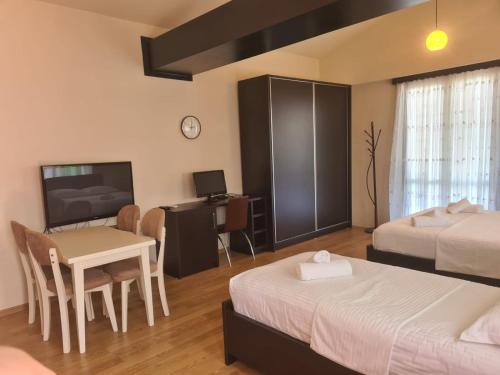 sypialnia z 2 łóżkami, stołem i biurkiem w obiekcie VILA 32 w mieście Berat