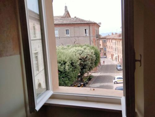 an open window with a view of a city street at ATTICO SULLA BOUGANVILLE (Albergo diffuso) in Corinaldo