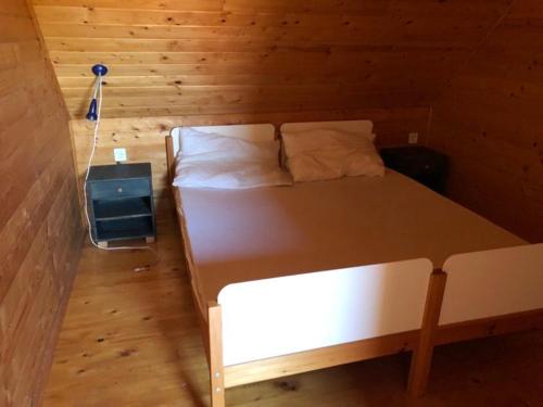 una camera da letto con letto in una camera in legno di Álmos Apartman a Balatonfenyves