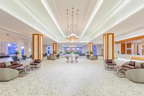 a lobby of a hotel with couches and flowers at Pickalbatros Villaggio Aqua Park - Portofino Marsa Alam in Marsa Alam City