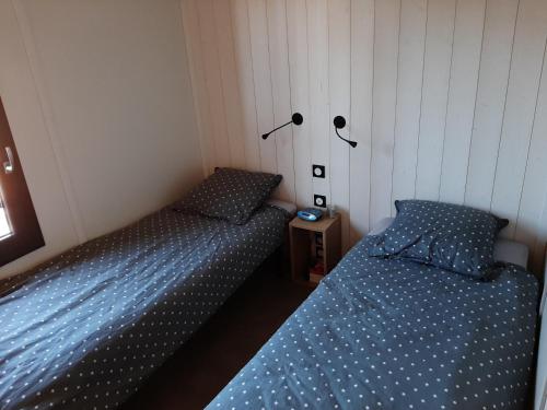 2 camas individuales en un dormitorio con sábanas azules en Cottage, en Jullouville-les-Pins