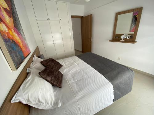 a bedroom with a white bed with a cross on it at Larnaca Bay Suites in Larnaka