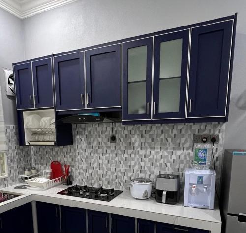 cocina con armarios azules y encimera en Majestic Homestay - Pasir Puteh, en Pasir Puteh