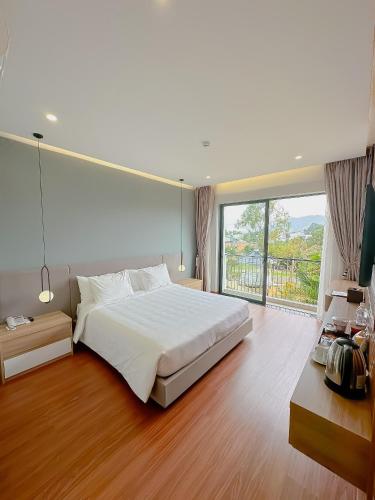 a bedroom with a large bed and a large window at Sunflower Hotel & Resort in Bảo Lộc