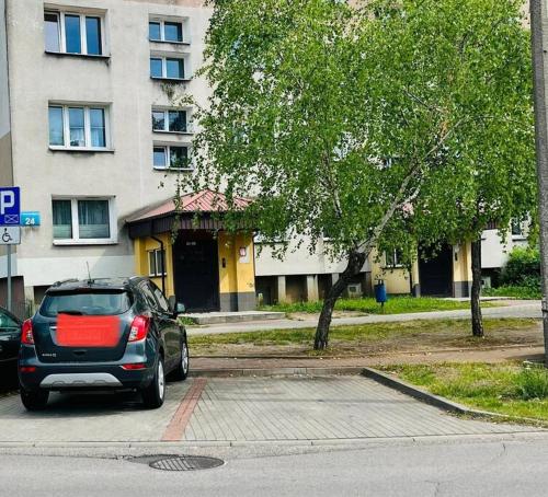 a car parked in a parking lot in front of a building at Nowomiejska Blisko Centrum in Suwałki