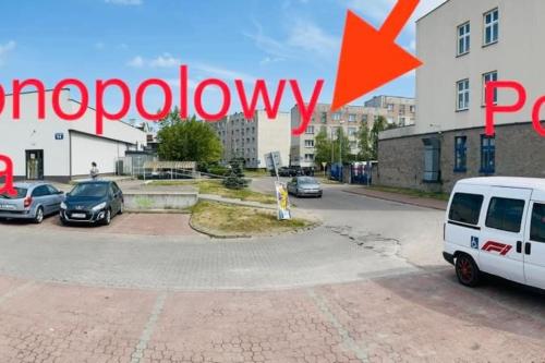 a street with cars parked in a parking lot at Nowomiejska Blisko Centrum in Suwałki