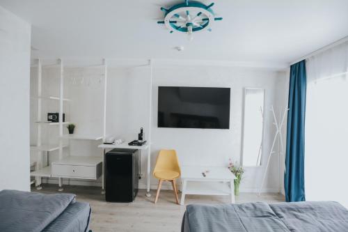 a white bedroom with a bed and a desk and a clock at WPO - WILD PIKE OASIS in Caraorman