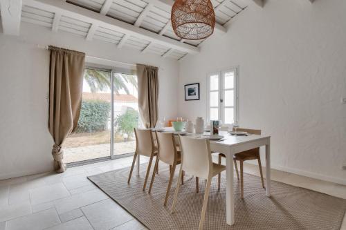 une salle à manger blanche avec une table et des chaises dans l'établissement 8 adultes - 2 enfants - Marais salants et plages, à Noirmoutier-en-l'lle