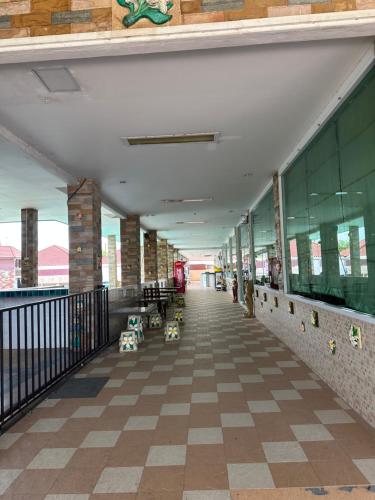 an empty hallway of a building with tables and chairs at Tuscany Hotel by skypark 