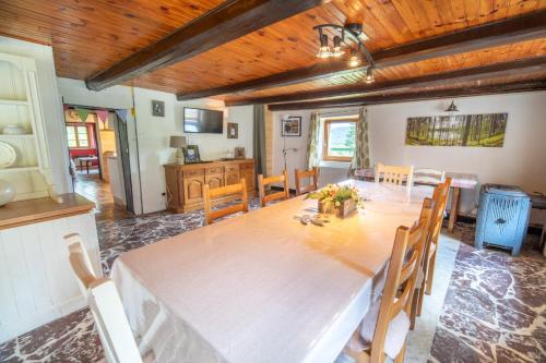 une grande salle à manger avec une table et des chaises dans l'établissement Charmante vieille ferme du Grand Père Prosper proche Gérardmer, à Liézey