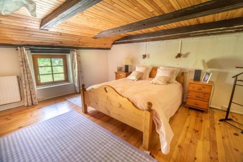 ein Schlafzimmer mit einem Bett und einer Holzdecke in der Unterkunft La Ferme du Grand Père Prosper in Liézey