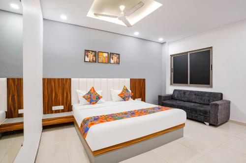 a bedroom with a bed and a chair at FabHotel Magnus in Surat